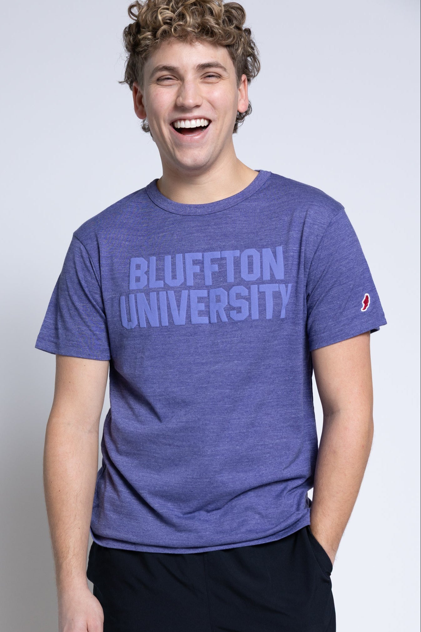 Person wearing a blue 'Bluffton University' t-shirt on a plain background
